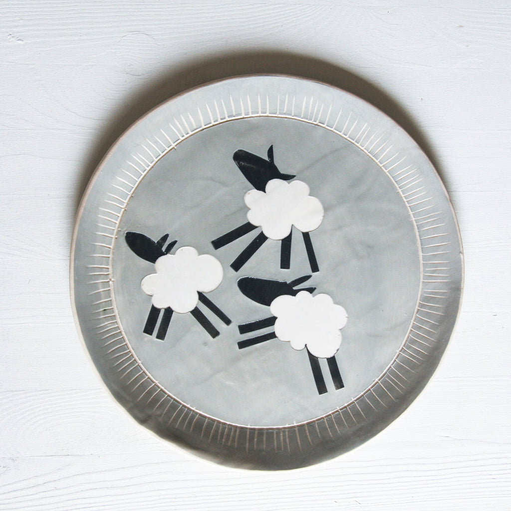Decorative plate with sheep design on a grey background