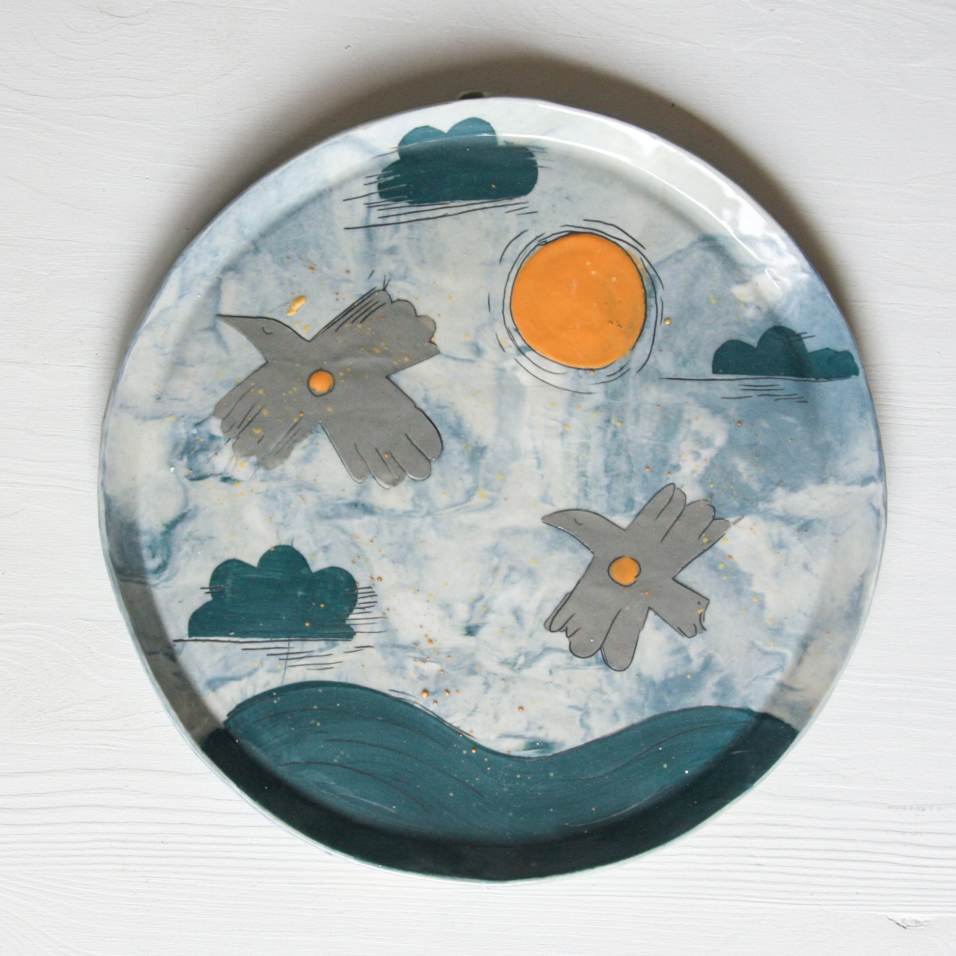 Ceramic plate with bird designs on a marbled background.
