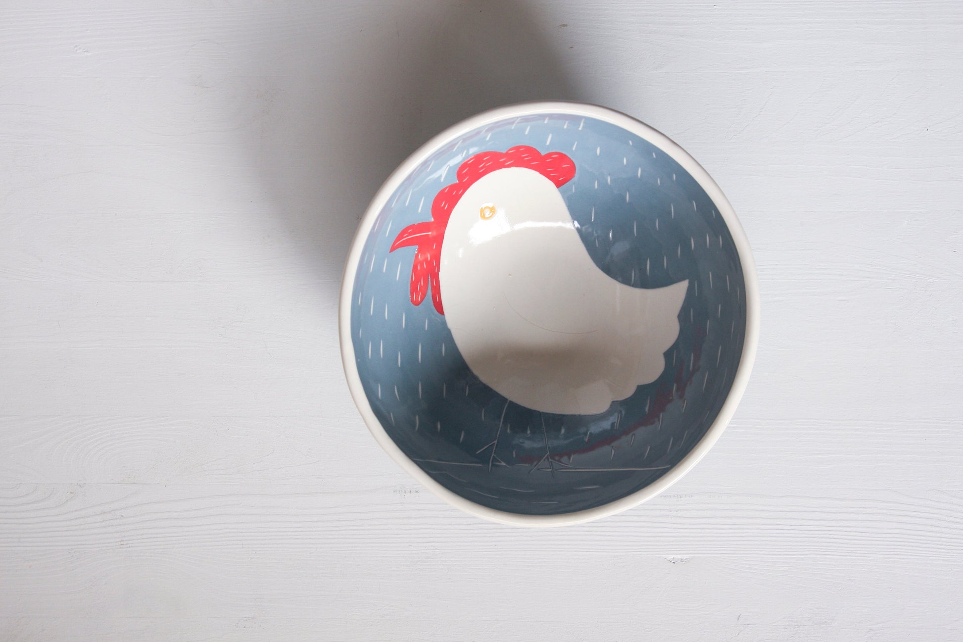Ceramic bowl with a hen design on a white background